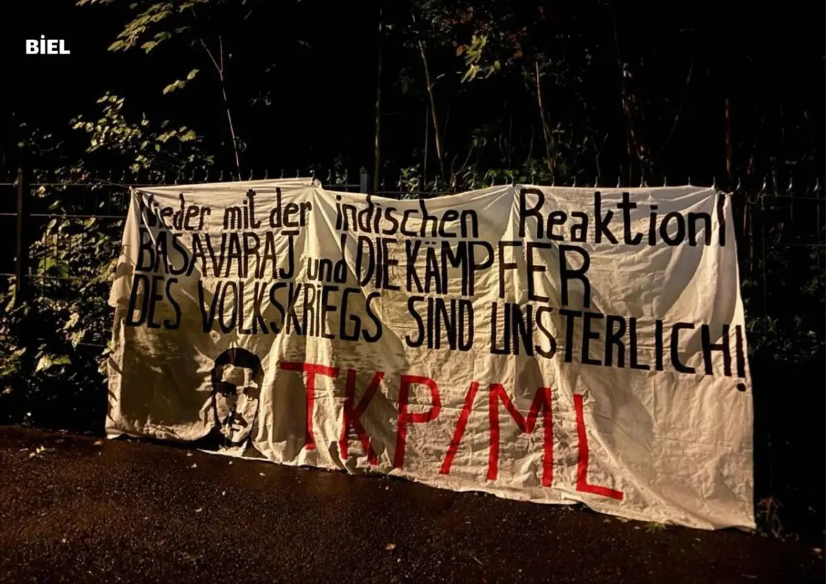 Political protest banner with German text about Indian reaction, photographed outdoors at night