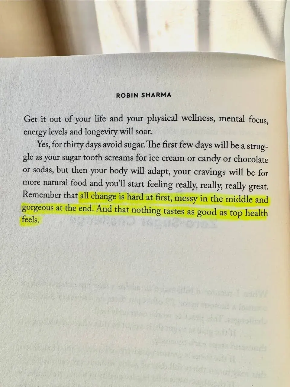 Portrait-oriented photo of a page from a Robin Sharma book discussing avoiding sugar for better health