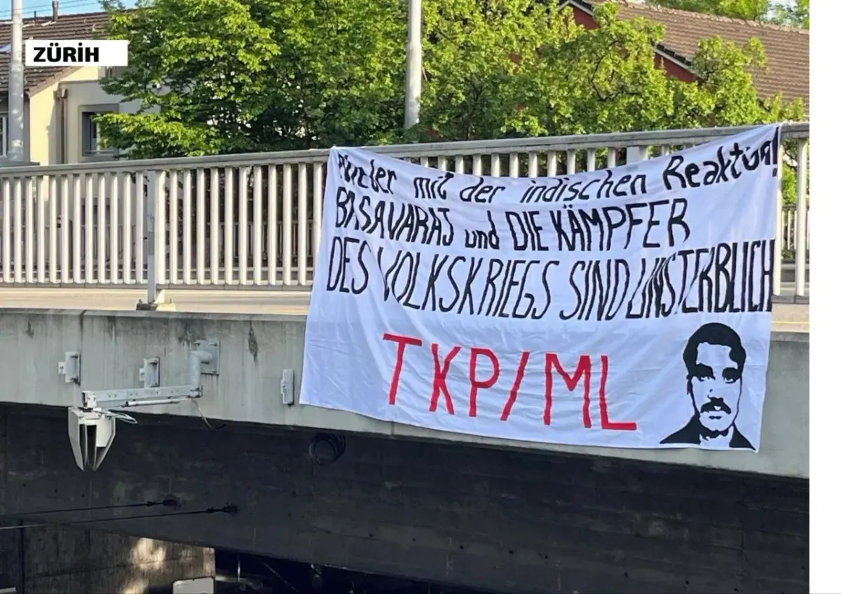 Outdoor protest-style banner with writing and a silhouette portrait hanging from a railing